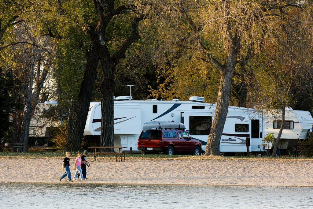 Visitors walk along the beach near the RV campground
