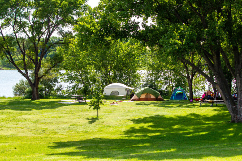 A family enjoys tent camping near the lake.