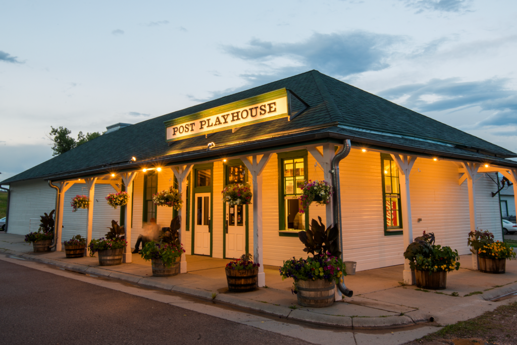 A white clapboard building with vintage sign at sunset