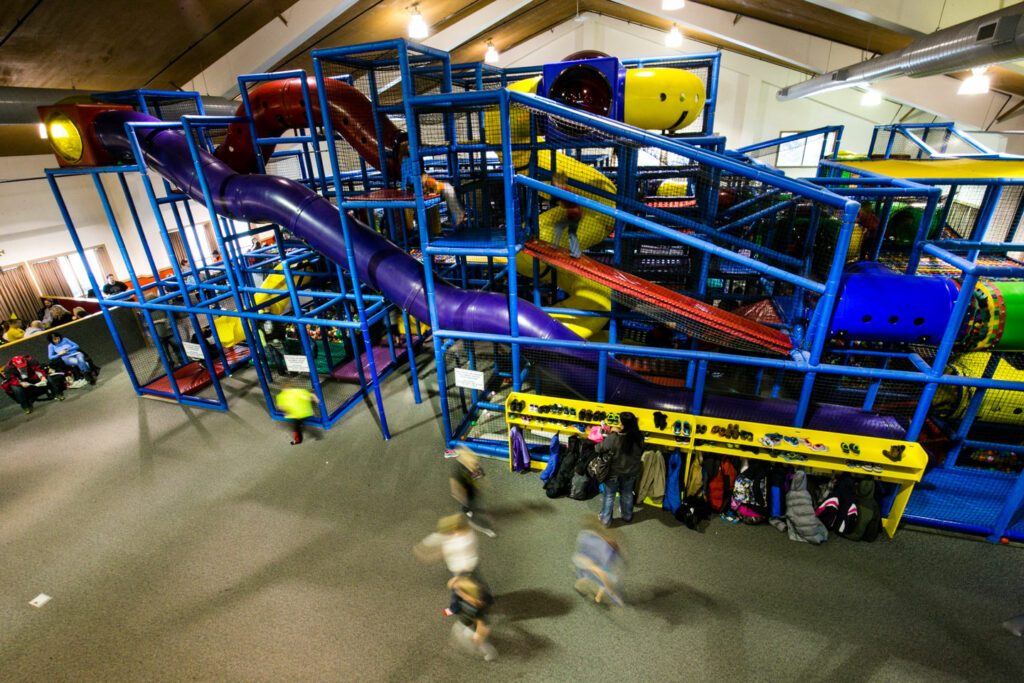 a brightly colored indoor playground with children playing
