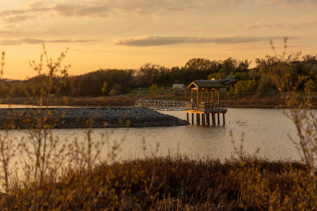 A lake near sunset time, a fishing pier jutting out over the water
