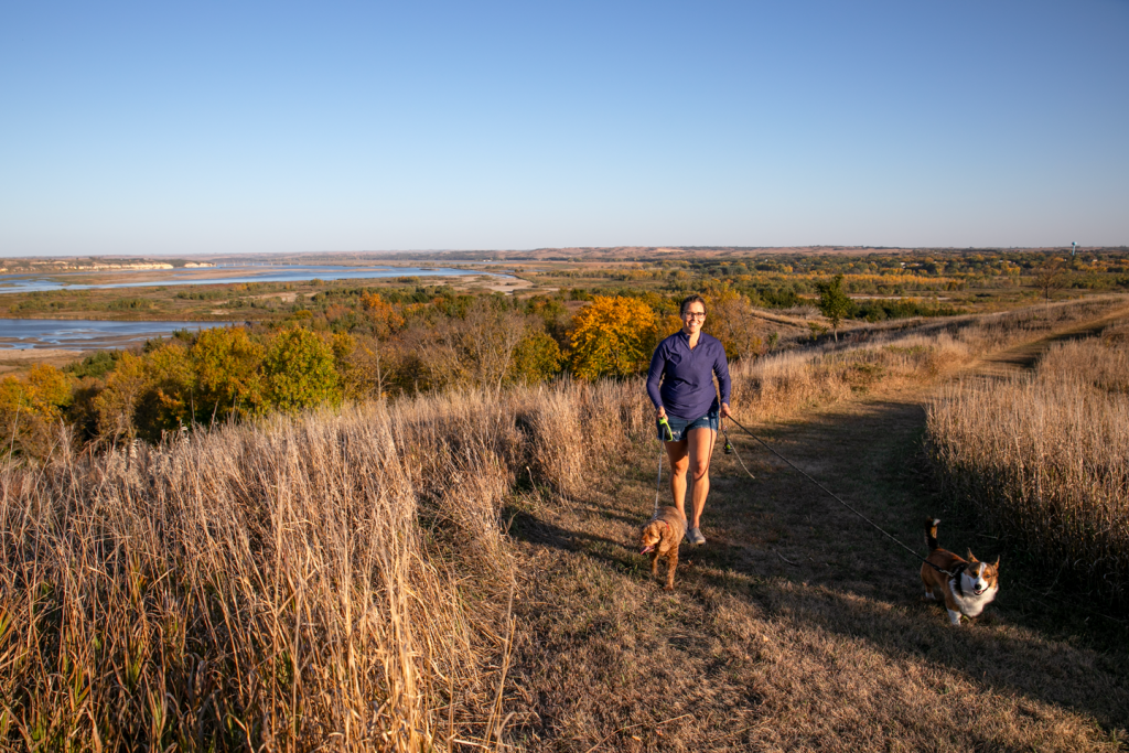 A woman walking dogs on the grass trail at Niobrara State Park.