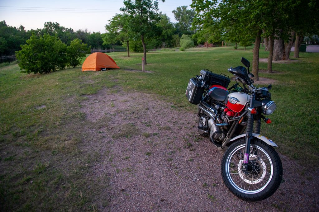 A motorcycle and tent in a campground