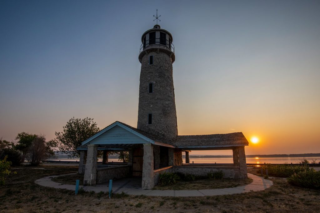 The sun rises behind the Lighthouse