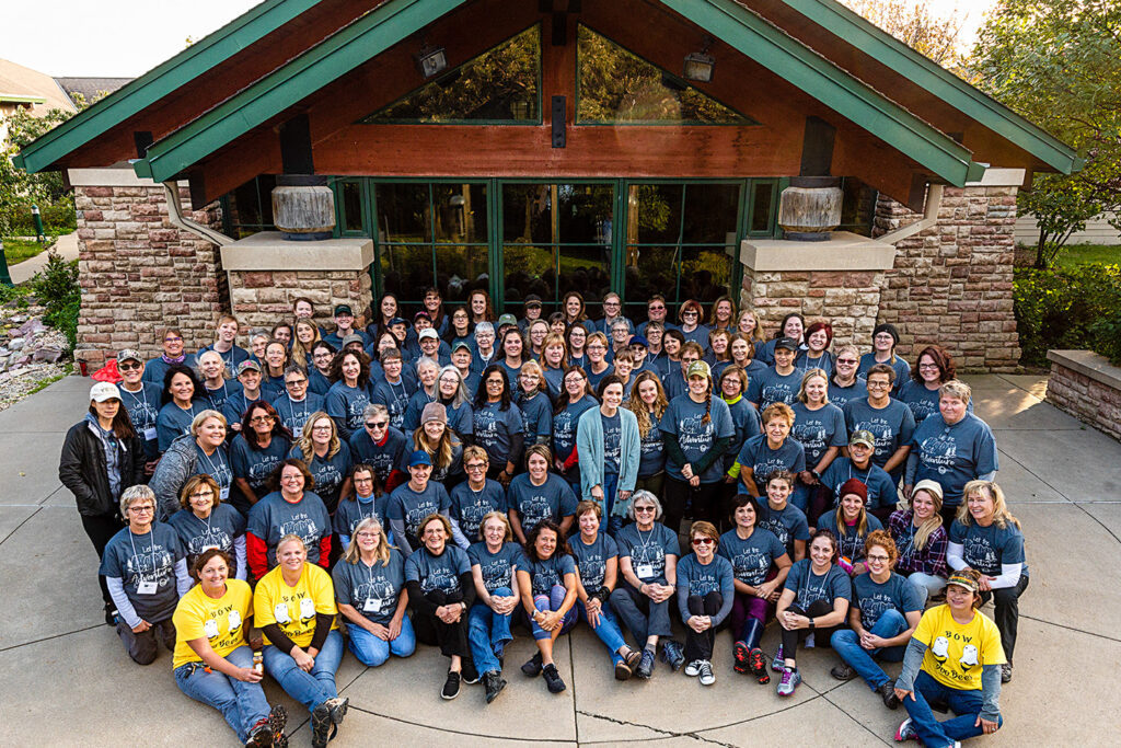 Participants and instructors smile and pose for a group photo during the Becoming an Outdoors Woman workshop at Ponca State Park in Nebraska