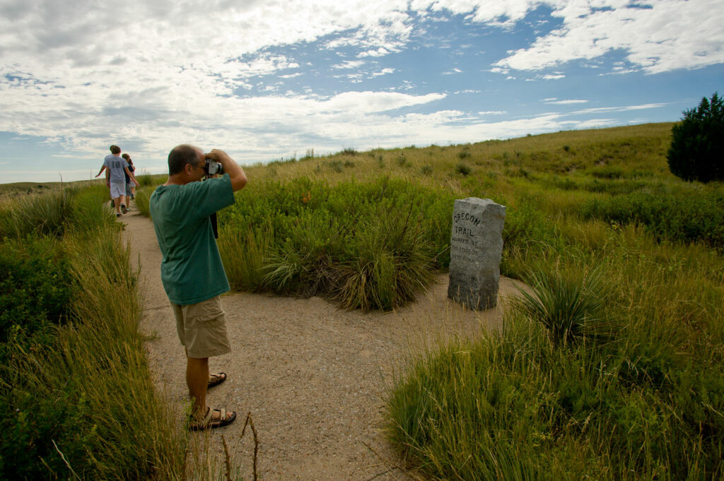 A man takes a picture of the Oregon Trail marker at Ash Hollow State Historical Park.