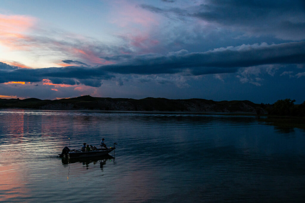 Men fish from a boat at dusk