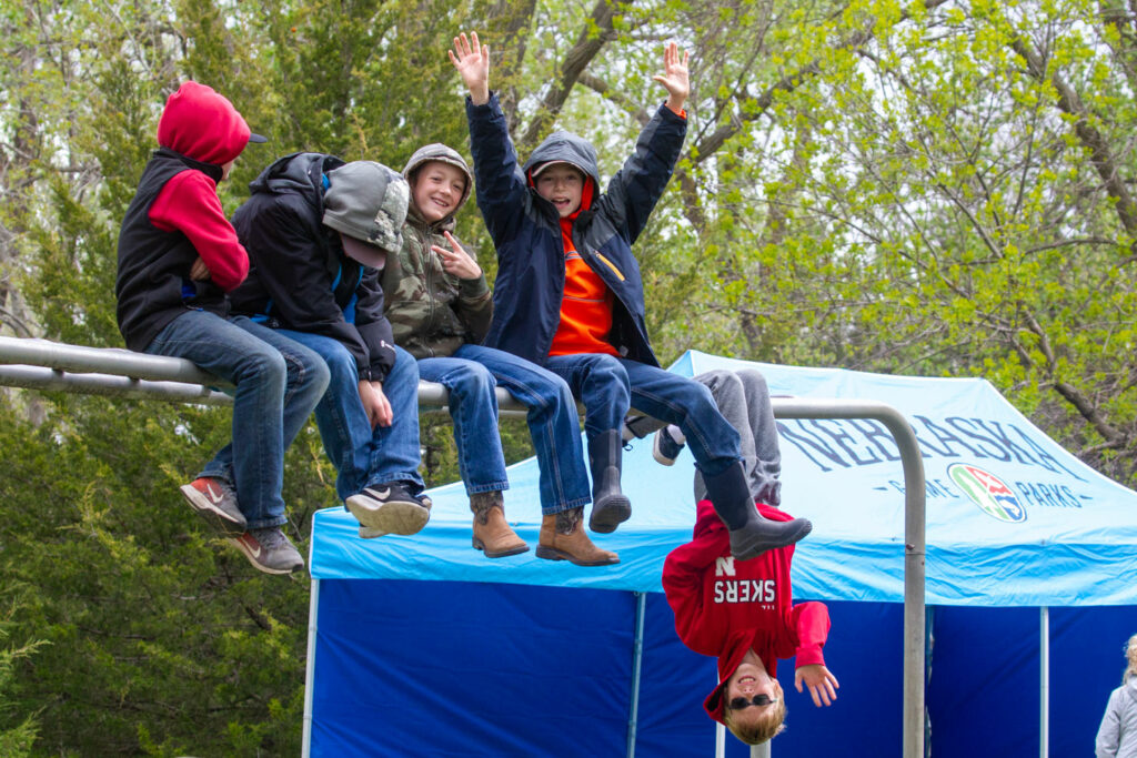 A group of elementary school boys hang out on some monkey bars at the Fort Kearny Outdoor Expo
