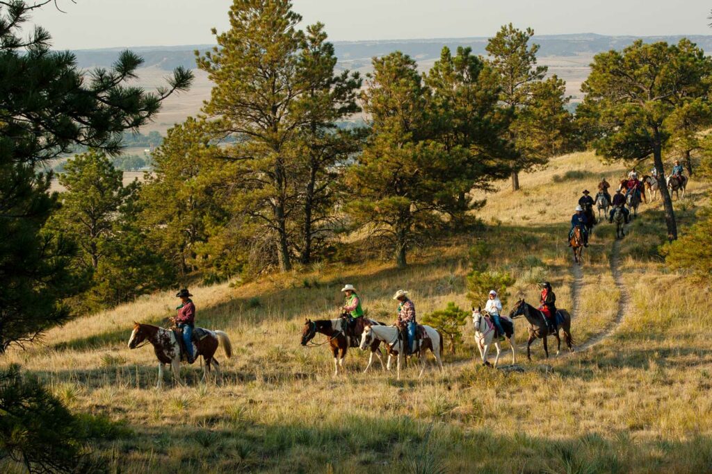 Horseback riders riding in the Pine Ridge at Fort Robinson.