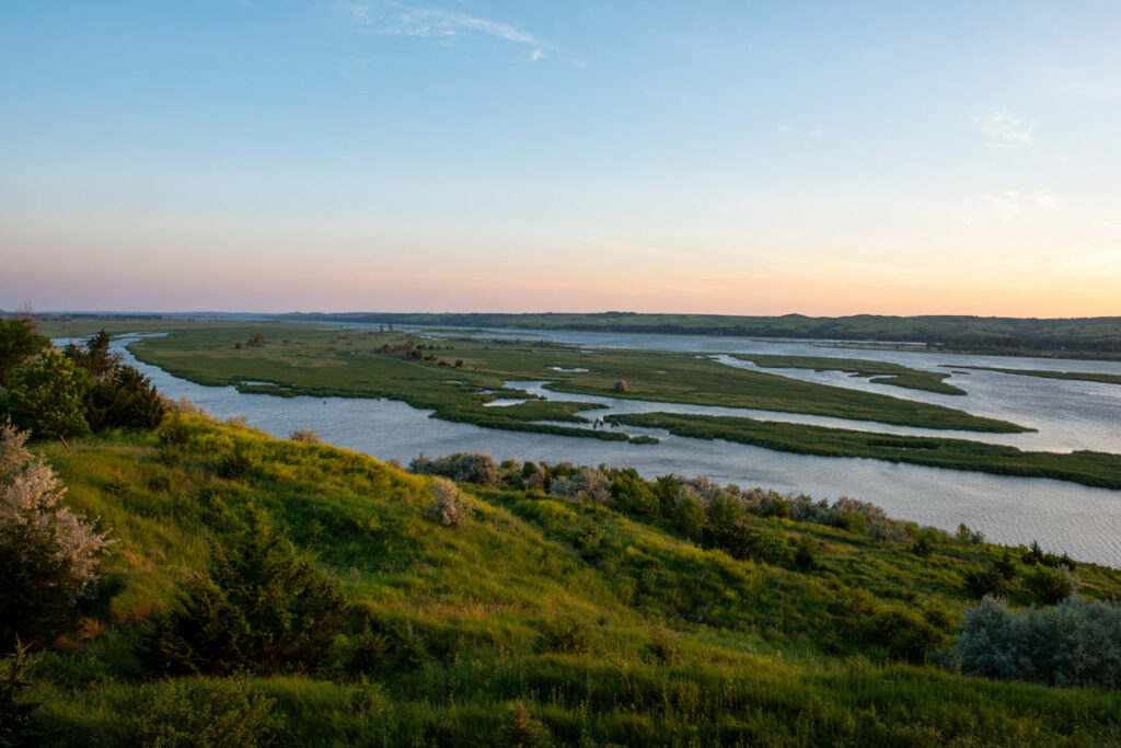 The Missouri River cuts through summer green prairie near Niobrara State Park.