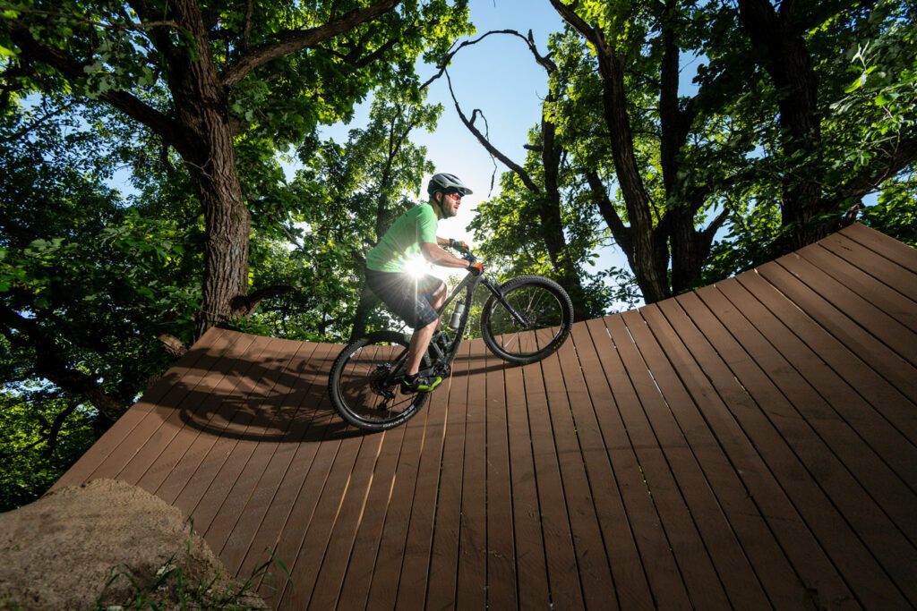 a mountain biker rides the curved wall on the trail