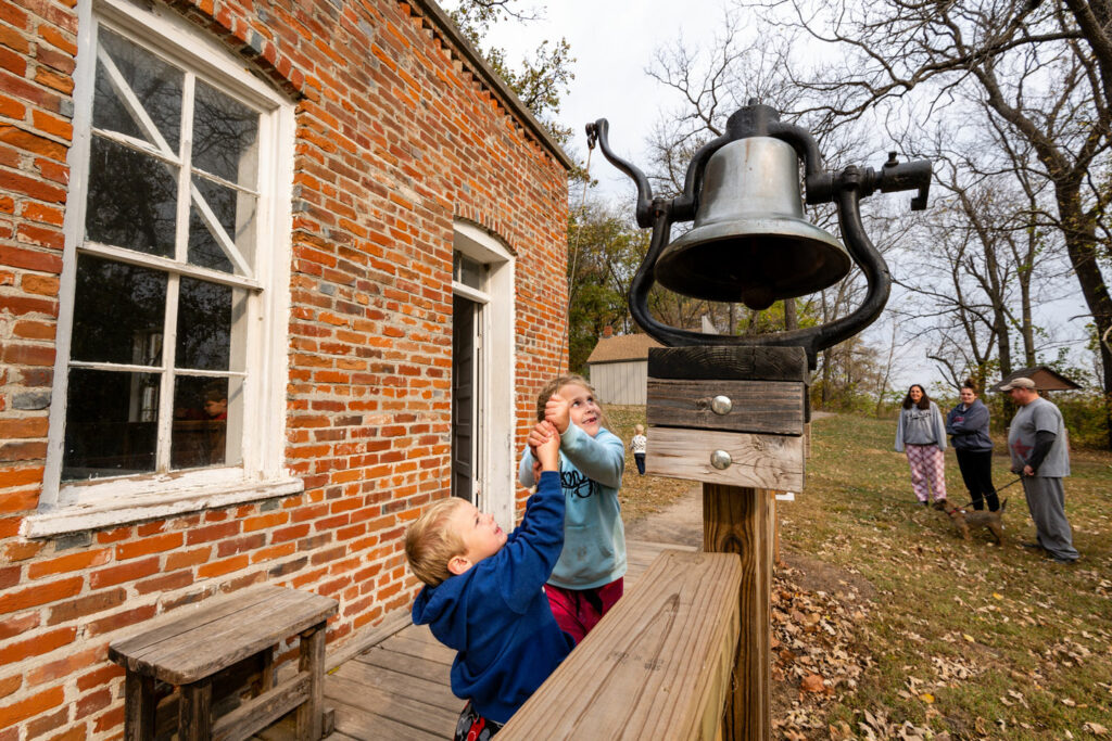 Children ring a vintage school bell
