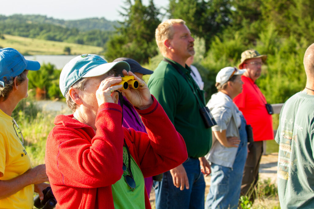 A woman holds binoculars to her face