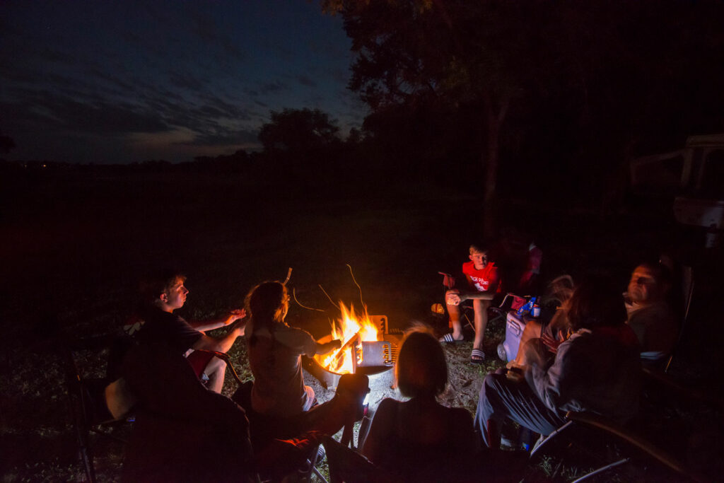 A campfire surrounded by campers
