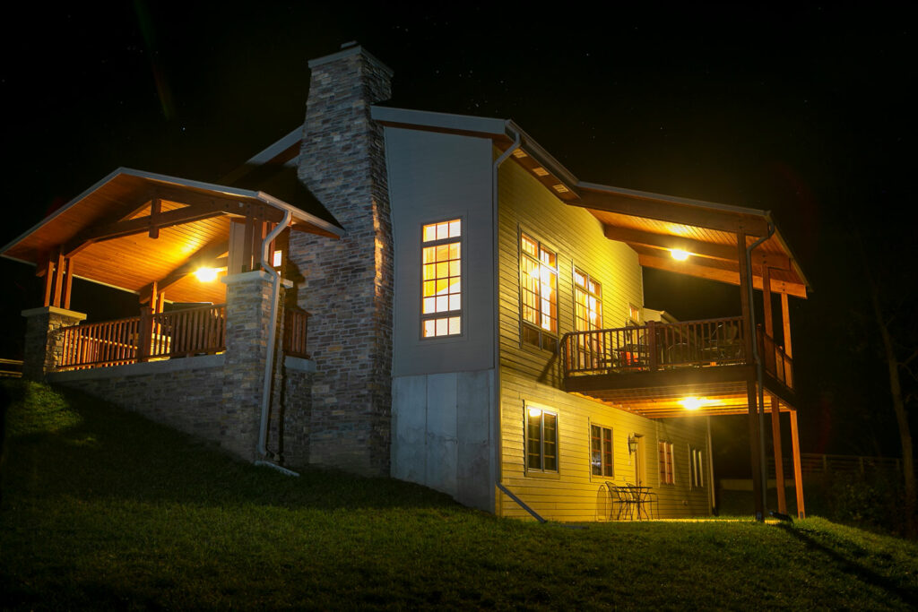 A large cabin's lights glow in the dark,