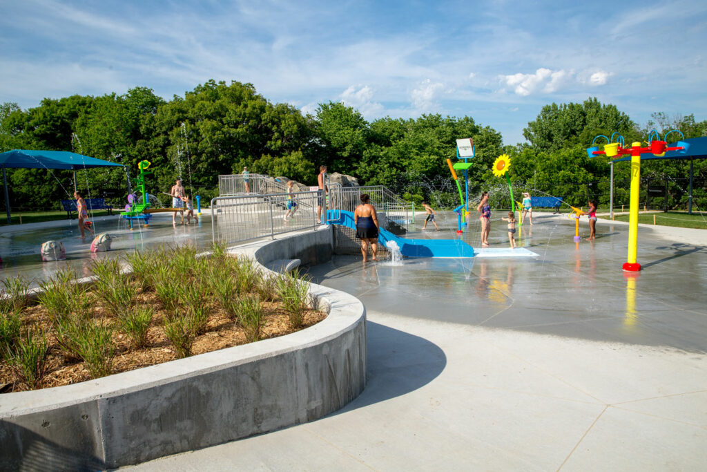 families play at the spray park on a summer day