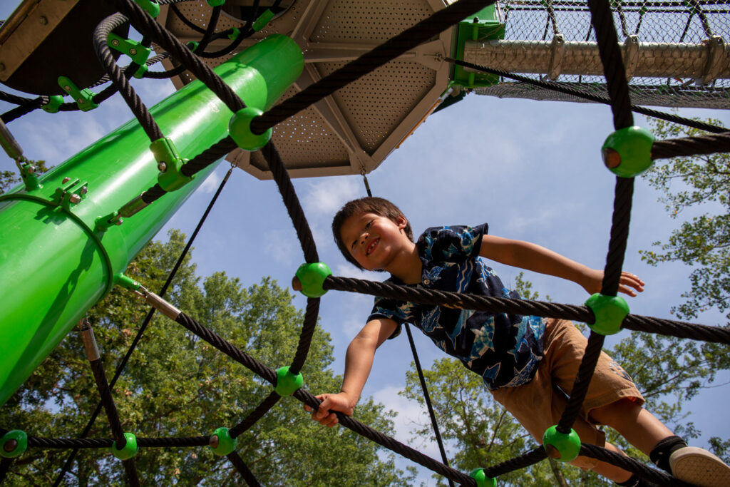 A boy climbs on a rope structure