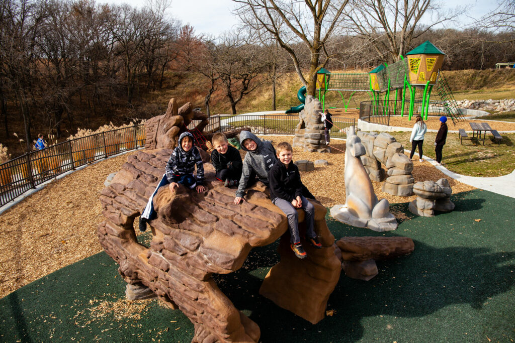 children climb on the natural features at the playground