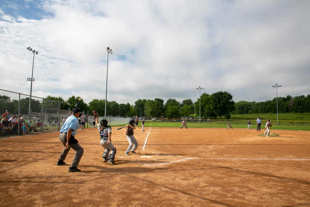 An umpire stands behind a batter.