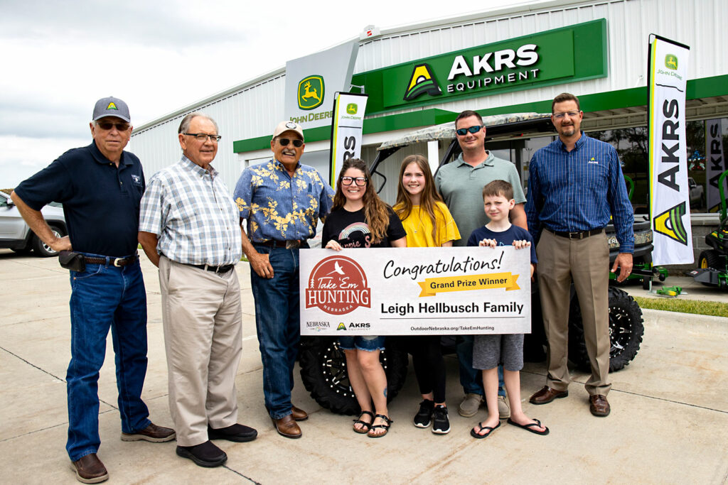 A family poses with a grand prize John Deere gator from AKRS Equipment that they won during the 2021 Nebraska Take 'em Hunting challenge.