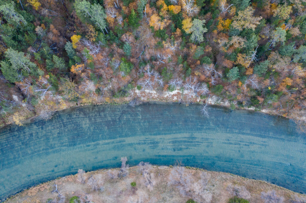 An aerial view of the Niobrara River during fall with trees along the shore near Smith Falls State Park.