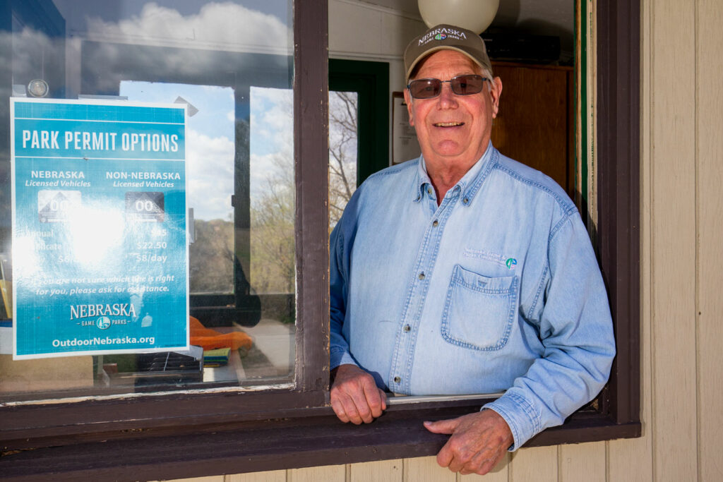 A park worker smiles from an information booth at a state park