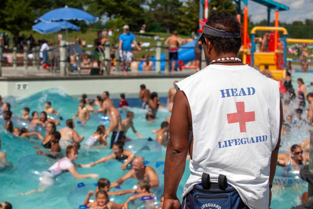 A lifeguard oversees people swimming in a pool