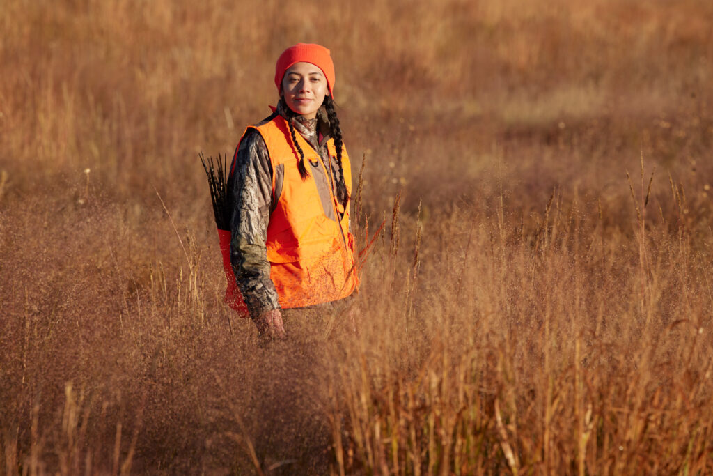 A woman hunts in a dry prairie field.