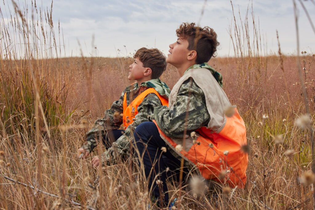 Two boys look into the sky while on a hunt