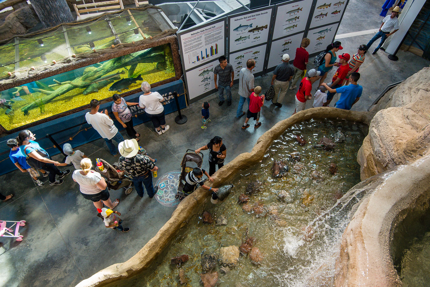 Aerial view of families walking through the Nebraska Game and Parks building displays and aquarium at the Nebraska State Fair.