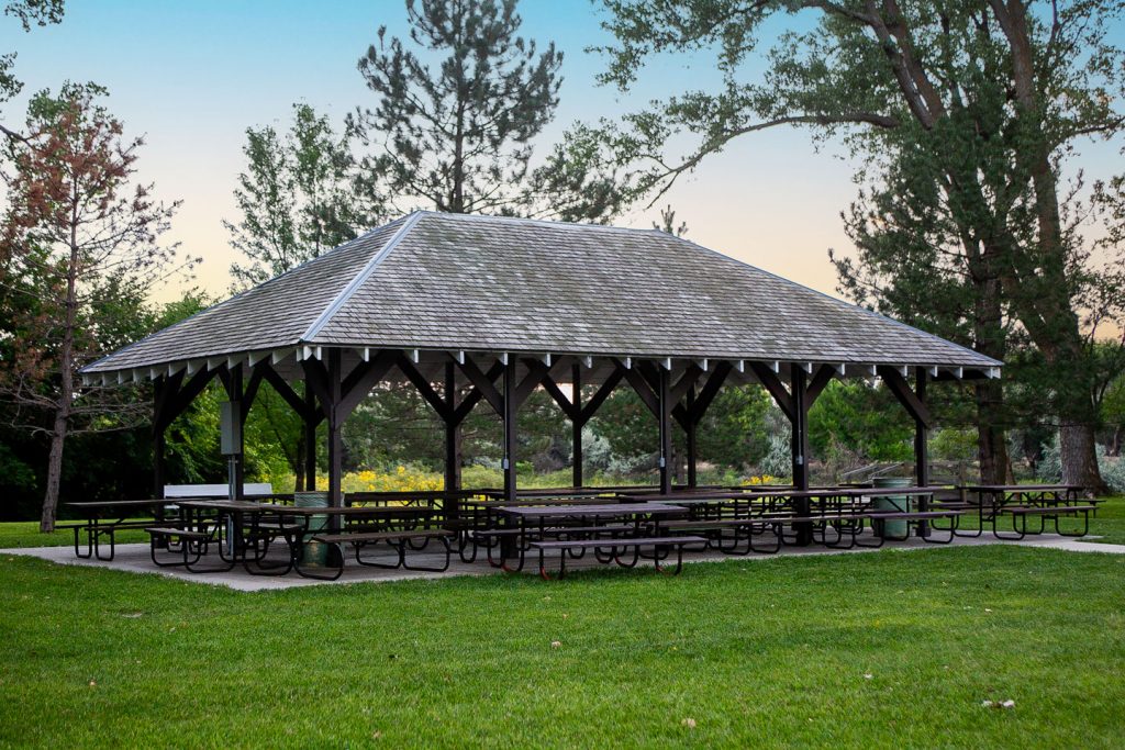 a large outdoor shelter with many picnic tables