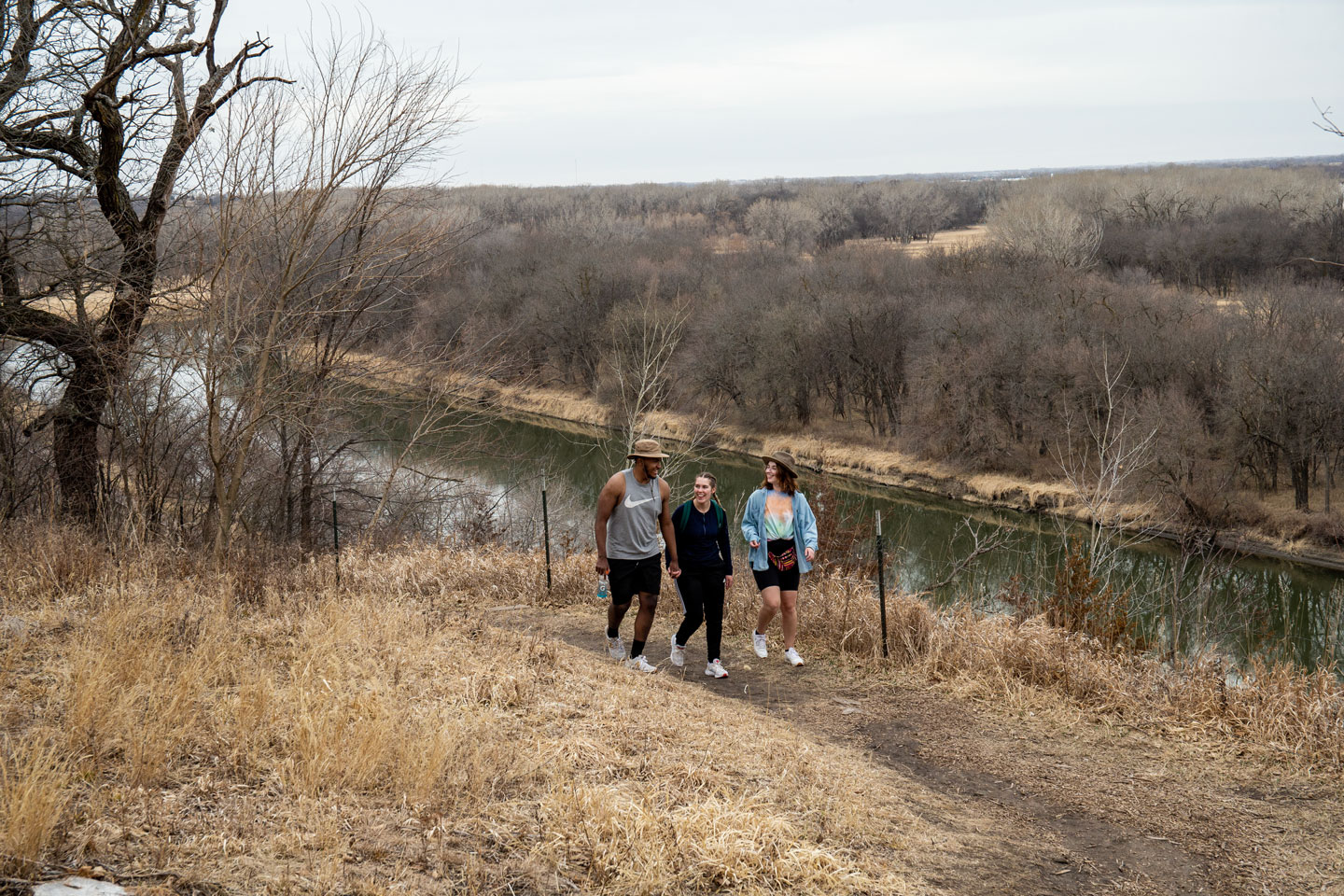 Three people hiking during early spring on a state park trail.