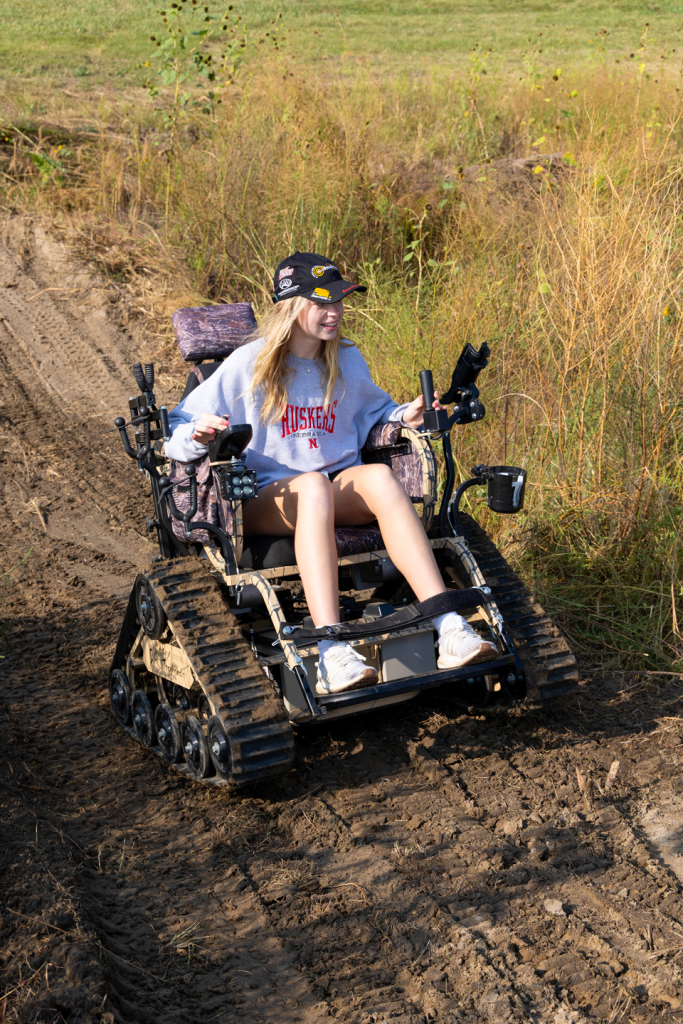 A girl rides in an all-terrain wheelchair