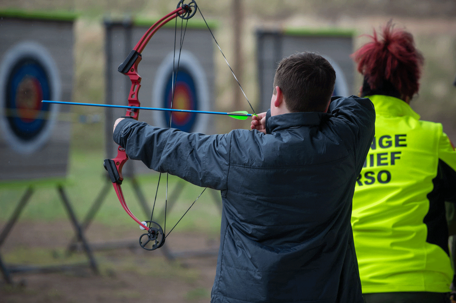 A boy shoots an arrow at a target