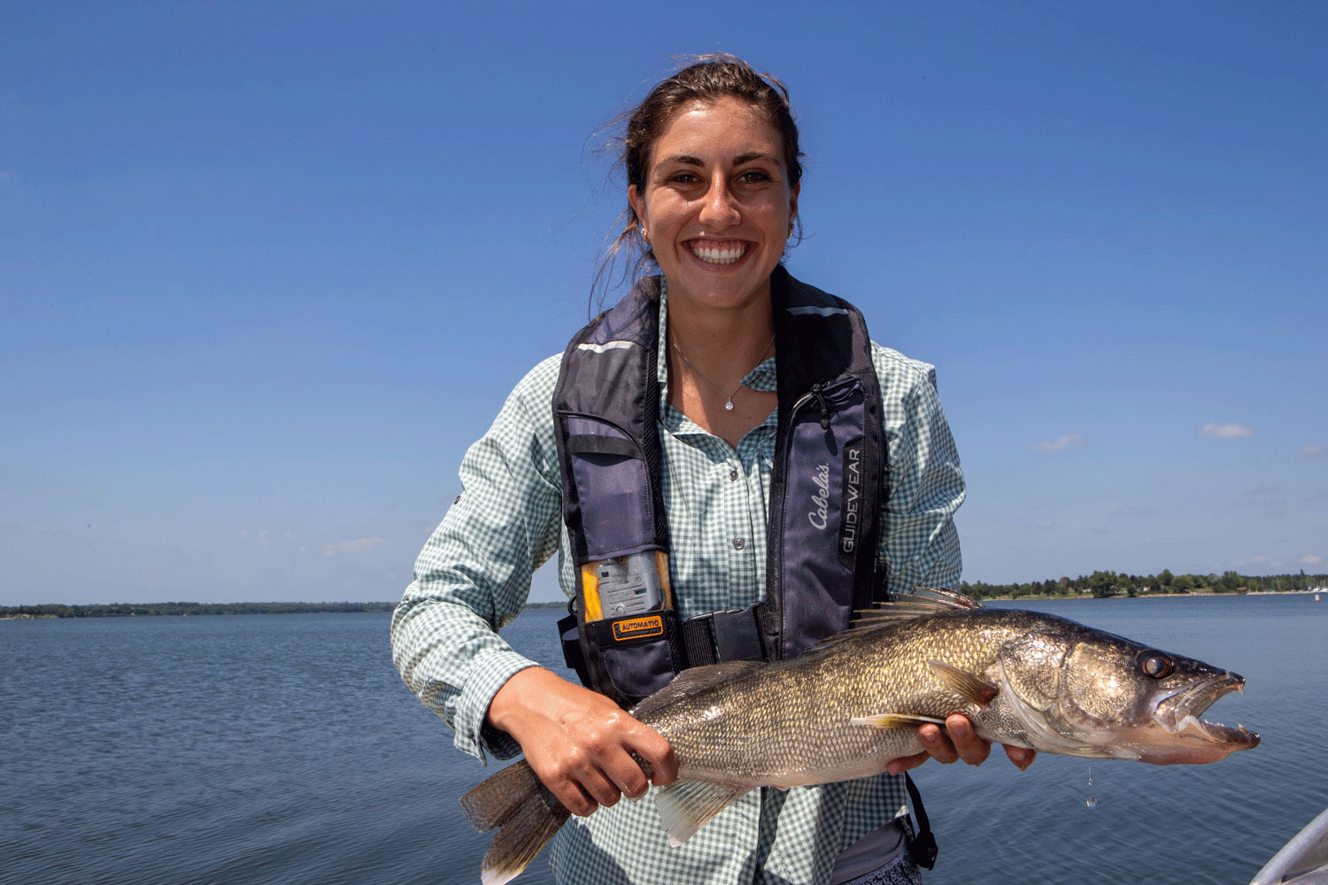 A woman holds a large walleye