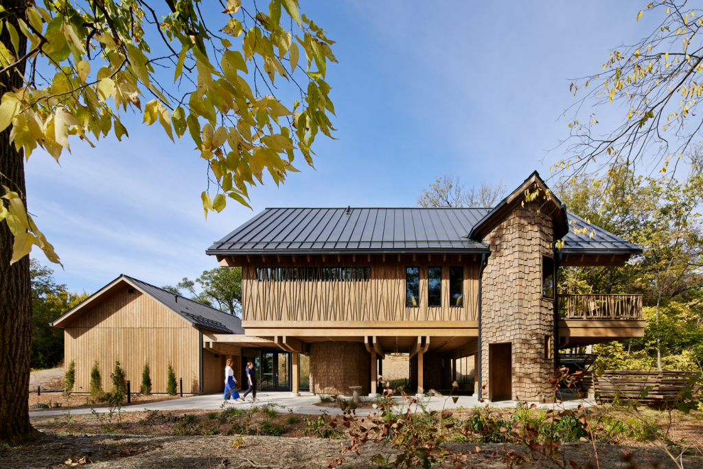 Two people walk outside of the new Treehouse building at Schramm Park State Recreation Area.